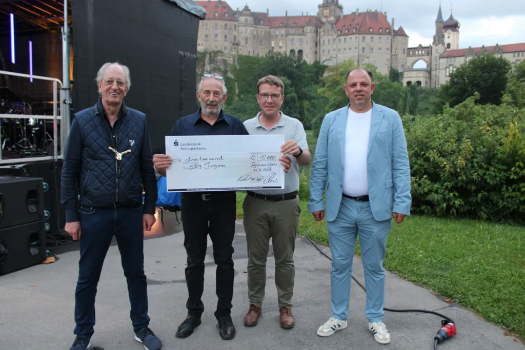 In der Pause überreichten Bandleader Karl Friedrich Fürst von Hohenzollern, der Gastronom Soufyen Charni sowie SZ-Redaktionsleiter Michael Hescheler an Burkhard Gerneth für die gemeinnützige Beschäftigungs- und Integrationsgesellschaft "gBIG" einen Scheck über 3000 Euro. (Foto: Gabriele Loges)